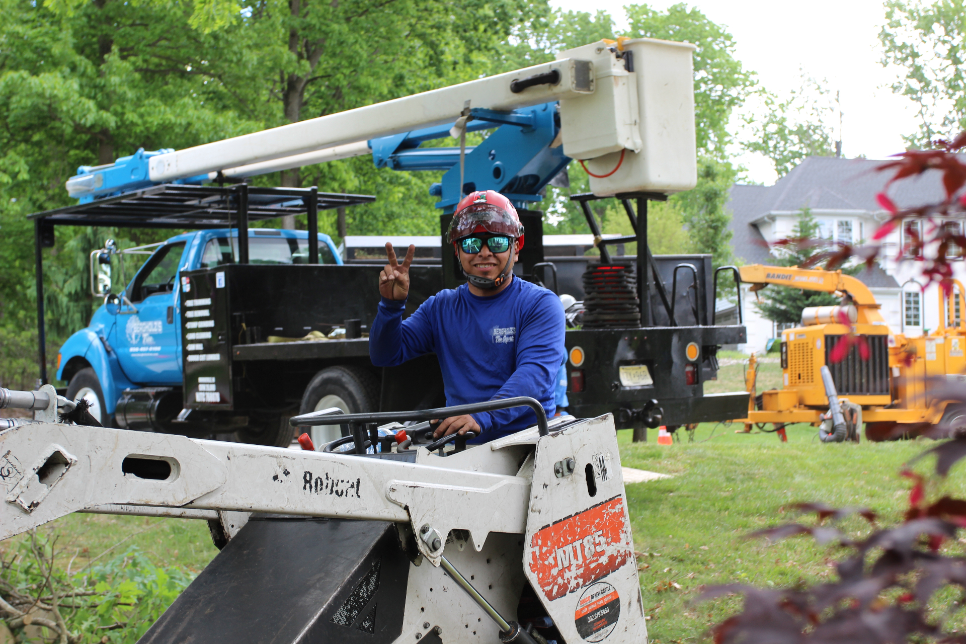 Arborist on the job with bucket truck and chipper